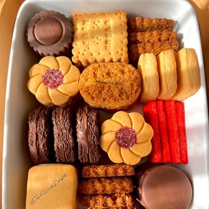 A tray of assorted biscuits including jam flowers and red sprinkle fingers.