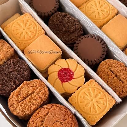 Rows of assorted biscuits packed into a white box.