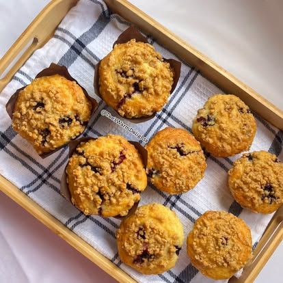 Blueberry muffins with domed tops on a checked cloth.