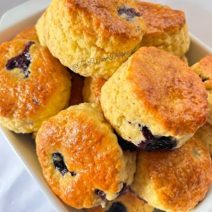 Blueberry scones piled in a cream bowl.