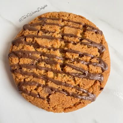 A large cookie criss-crossed with caramel drizzle.