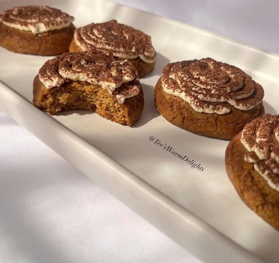 Carrot muffins dusted with cinnamon on a white plate.