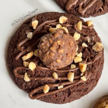 A chocolate cookie topped with a hazelnut chocolate and nuts.
