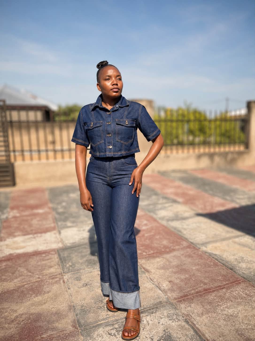 Tiyiselani, founder of Tee's Warm Delights, standing outside in a denim set.