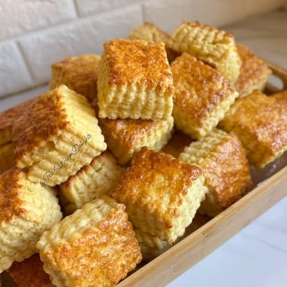 Golden flavoured scones piled in a paper-lined box.