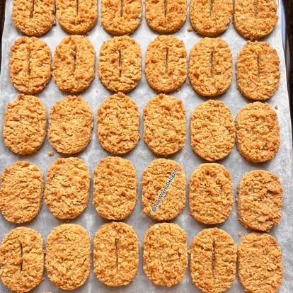 Rows of oat nuttikrust biscuits on a baking tray.