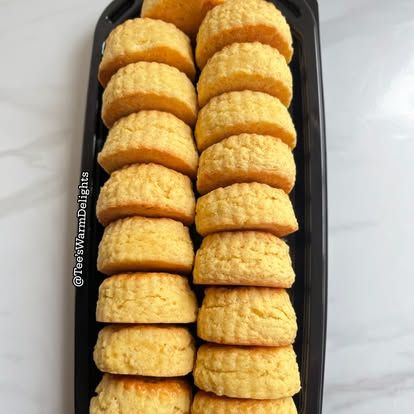 Two neat rows of scones in a black serving tray.
