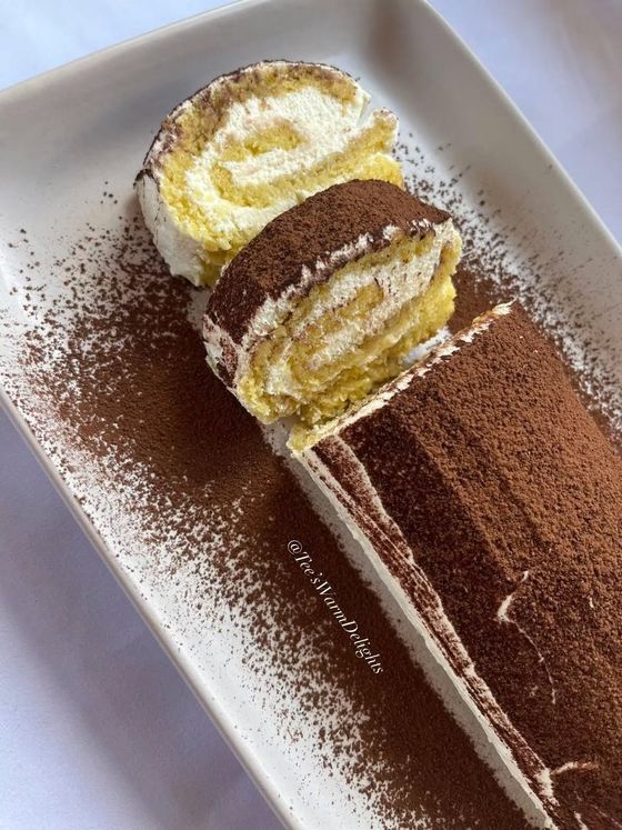 A sliced tiramisu roll showing the cream swirl inside.